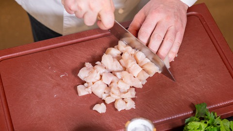 Rezept Ragout fin: Hühnchenfleisch wird in feine Würfel geschnitten.