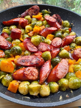 Rezept: Rosenkohl, Karotten und Mettenden angebraten in einer Pfanne.