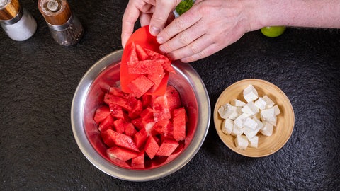 Wassermelone: Klein geschnittene Stückchen werden neben dem Fetakäse in eine Schüssel gegeben.