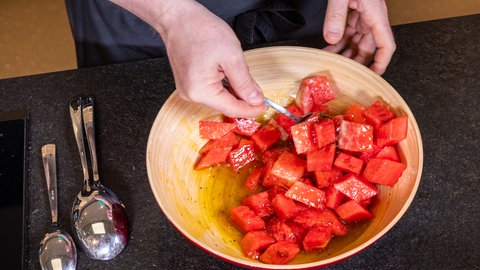 Wassermelonen-Salat: Die Wassermelonen-Stückchen werden im Limetten-Dressing gewälzt.