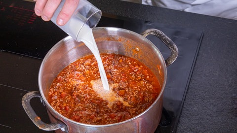 Original italienische Bolognese Soße wird mit Milch in einem Topf zubereitet.