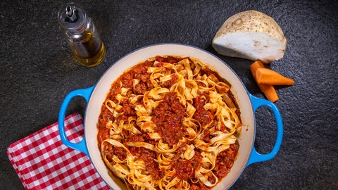 Ragù alla Bolognese: Die leckere Soße ist mit Nudeln vermengt und angerichtet auf einem Teller zu sehen.