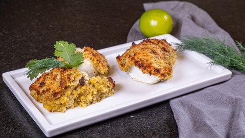 Fisch Rezept fertig zubereitet: Das Fischfilet Bordelaise aus Kabeljau liegt mit der knusprigen Panade fertig paniert auf einem Teller.