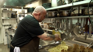 Spätzlefenster Ulm: Ein Mitarbeiter bereitet in der Küche Spätzle zu