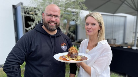 Mann und Frau halten Zwiebelrostbraten in die Kamera