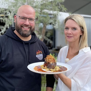 Mann und Frau halten Zwiebelrostbraten in die Kamera