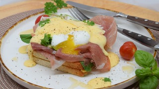 Eggs Benedict oder Eier Benedict auf Toast mit Schinken und Sauce Hollandaise.