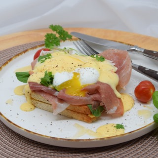 Eggs Benedict oder Eier Benedict auf Toast mit Schinken und Sauce Hollandaise.