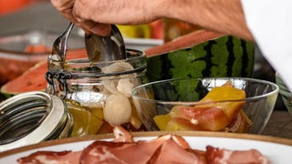 Eberhard Braun nimmt aus einem Einmachglas eingelegte Melonenschalen heraus
