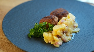 Ein Teller mit Frikadellen und schlotzigem Kartoffelsalat.