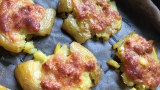 Eine würzige Käse-Knoblauchkruste verleiht diesen Smashed Potatoes Suchtpotenzial.