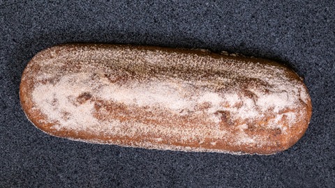 Fertiger Stollen mit Cranberrys in Zimt und Zucker gewälzt