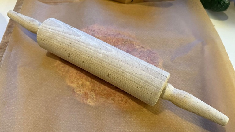 Hackfleisch zwischen Backpapier zu einem dünnen Fladen ausgerollt.