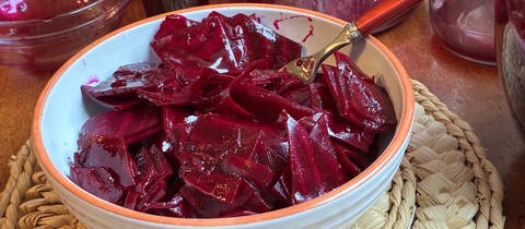 Rote Bete in einer Schüssel steht auf einer Platzunterlage auf einem Tisch