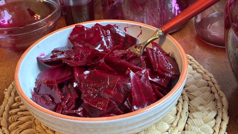 Rote Bete in einer Schüssel steht auf einer Platzunterlage auf einem Tisch