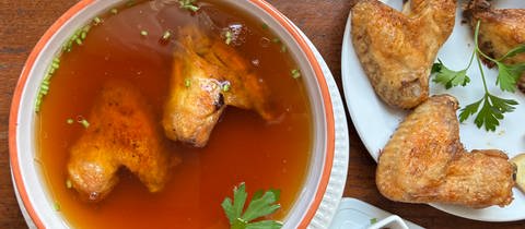 Zwei Hühnerflügel in einer Schüssel mit Sojasauce