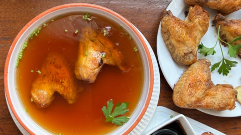 Zwei Hühnerflügel in einer Schüssel mit Sojasauce