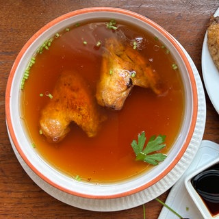 Zwei Hühnerflügel in einer Schüssel mit Sojasauce