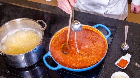 Wenn die vegetarische Bolognese aus Linsen fertig ist, werden die Spaghetti abgekocht. Zuletzt kommt noch etwas Nudelwasser in die Bolognese.
