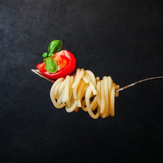 Eine Gabel mit Spaghetti und rohen Tomaten sowie Basilikum: Spaghetti alla Crudaiola