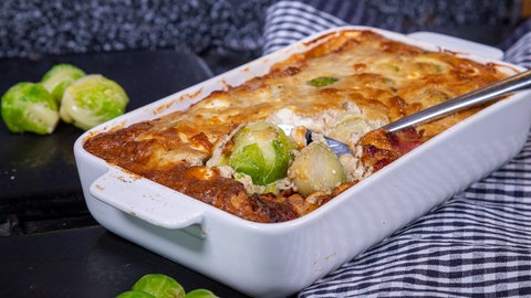 Rosenkohl-Gratin: Rosenkohl, nach Rezept mit viel Käse überbacken, in einer Auflaufform angerichtet.