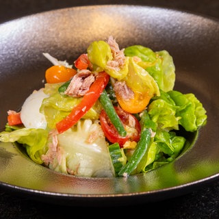 Der original Nizza-Salat ist wie im Rezept beschrieben mit Ei und Thunfisch zubereitet worden und ist in einer schönen Schüssel angerichtet.