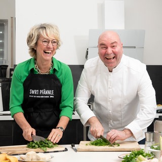 SWR1 Moderatorin Petra Klein und SWR1 Pfännle-Koch Eberhard Braun stehen in einer Küche und kochen zusammen.