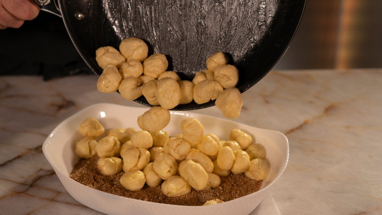 Teigbällchen in der Zimt-Zucker-Mischung wälzen. 