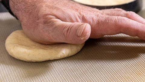 Rezept Burgerbrötchen selber machen: Teig der Burgerbrötchen flachdrücken.