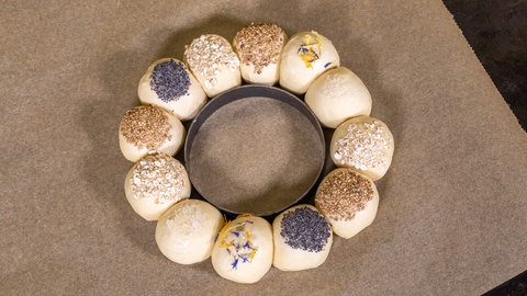 Die Brötchen werden zum Backen auf ein Backpapier gelegt.