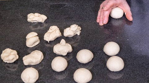 Der Teig des Laugengebäcks für den Laugenkranz wird, wie im Rezept beschrieben, zu Kugeln geformt.