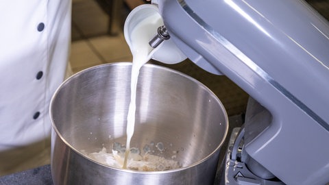 Teigherstellung für den Laugenkranz als Partysnack: Lauwarme Milch wird, wie im Rezept erwähnt, in eine Schüssel gegeben. 