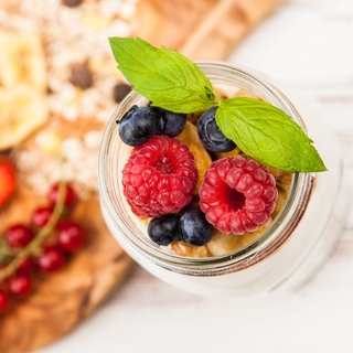 Dessert mit Beeren und Banane im Glas