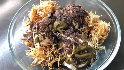 Eisbecher mit Vanilleeis mit Pistazienmus, Schokolade und Engelshaar