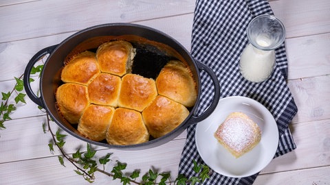 Die frischen Dampfnudeln mit Vanillesauce wurden - wie im Rezept beschrieben - zubereitet und stehen auf einem Tisch.