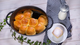 Die frischen Dampfnudeln mit Vanillesauce wurden - wie im Rezept beschrieben - zubereitet und stehen auf einem Tisch.