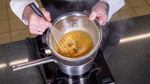 Die Zutaten für das Parfait für die Eistaler werden in einem Wasserbad erhitzt und vermengt.