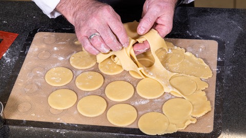 Der Teig für die Kekse für die Eistaler wird mit einem runden Ausstecher ausgestochen.