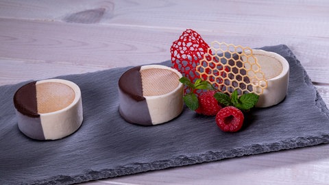 Köstliche Eistaler – Kekse und Parfait – mit Schokoglasur und Deko als Dessert auf einem Servierbrett angerichtet