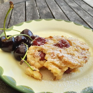 Kirschmichel nach Originalrezept auf einem Dessertteller mit frischen Kirschen als Deko