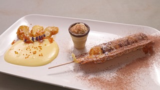 Karamellisierte Apfelspalten mit Vanillesoße an gefüllter Waffel am Stiel und Eierlikörchen