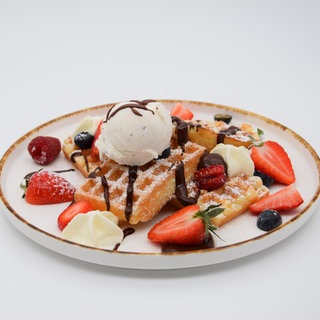 Belgische Waffeln mit Beeren und Eiscreme auf einem Teller angerichtet. Belgische Waffeln sind dicke Waffeln mit tiefem Muster und viel Platz für Toppings wie Beeren, Puderzucker oder Eiscreme. SWR1 Pfännle-Koch Eberhard Braun hat das Rezept für euch.