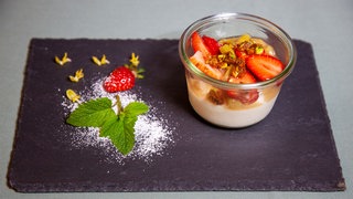 Joghurtmousse mit Erdbeer-Rhabarberkompott serviert auf einer Schieferplatte