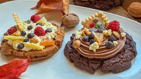 Zwei große SWR1 Pfännle Over the Top Cookies liegen auf einem Teller, aufwändig belegt mit kreativen Toppings.