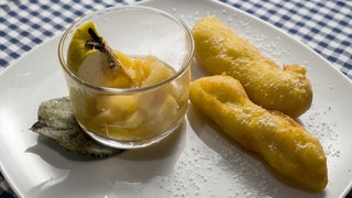 Kartoffelstumpen mit Quittenmus und Puderzzucker auf dem Teller