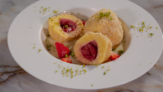 Erdbeerknödel auf einem Teller angerichtet. Das SWR1 Pfännle-Rezept schmeckt nach Sommer. Dazu gibt's Vanillesauce und frische Erdbeeren.