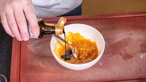 Sojasoße wird in ein Gefäß geschüttet