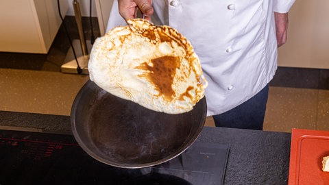 Pfannkuchen wird in der Pfanne gewendet