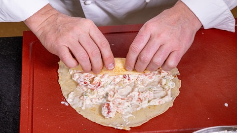 Die Pfannkuchen mit der Füllung werden aufgerollt
