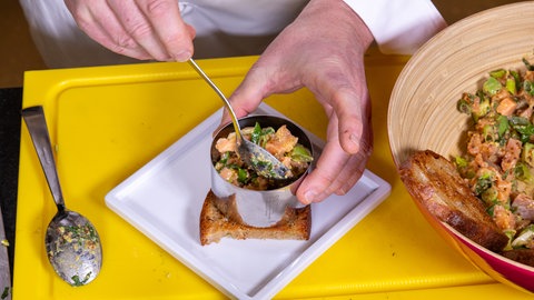 Das Lachstatar wird auf dem gerösteten Brot gehäuft.